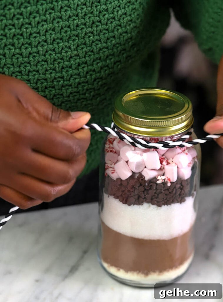 woman assembling a hot cocoa mix in a jar