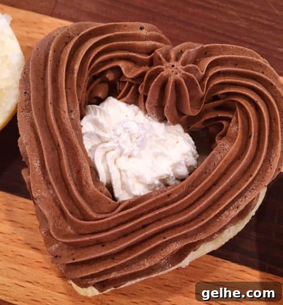 Puff pastry being filled with chocolate filling and whipped cream