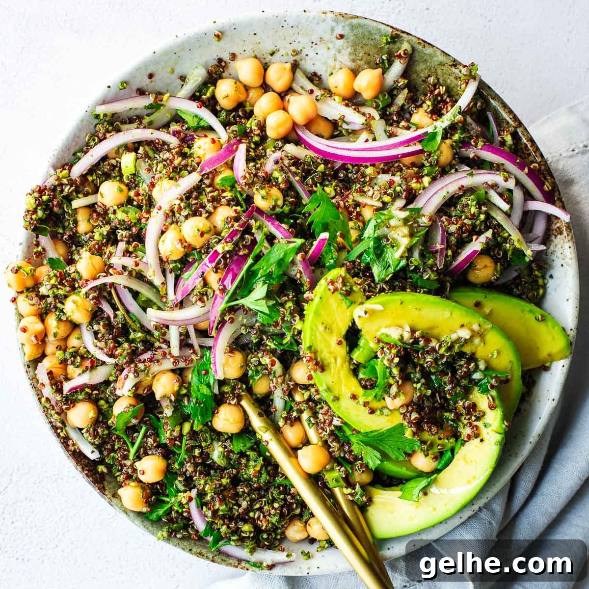 Quinoa salad with basil, kale and almond pesto topped with avocado and a lemon dressing.