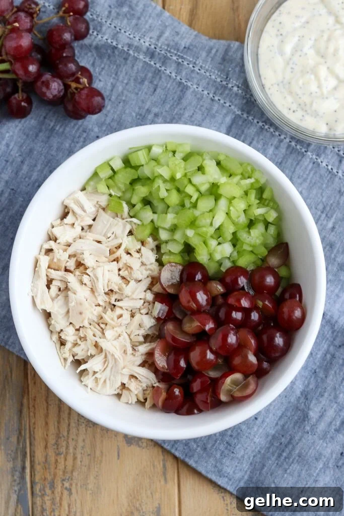 chopped cooked chicken, diced celery and red grapes in a large mixing bowl