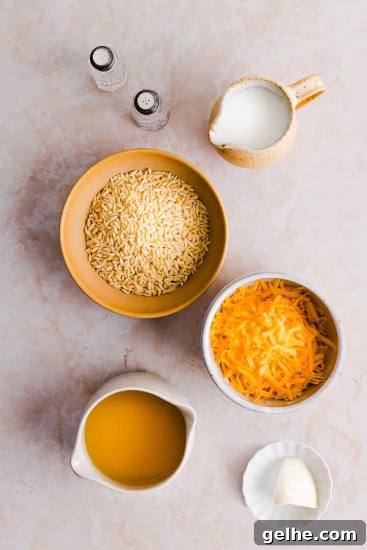Creamy One-Pot Orzo with Cheese 4 Ingredients for one-pot cheesy orzo displayed in small bowls on a marble counter