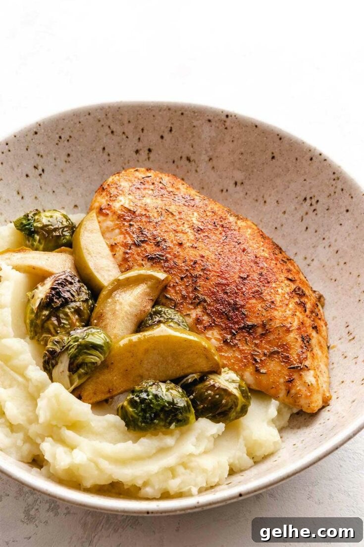 Chicken with apples and Brussels sprouts on plate.