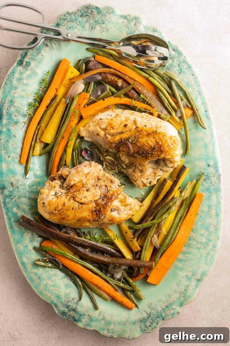 Dutch oven chicken breasts with vegetables on platter.