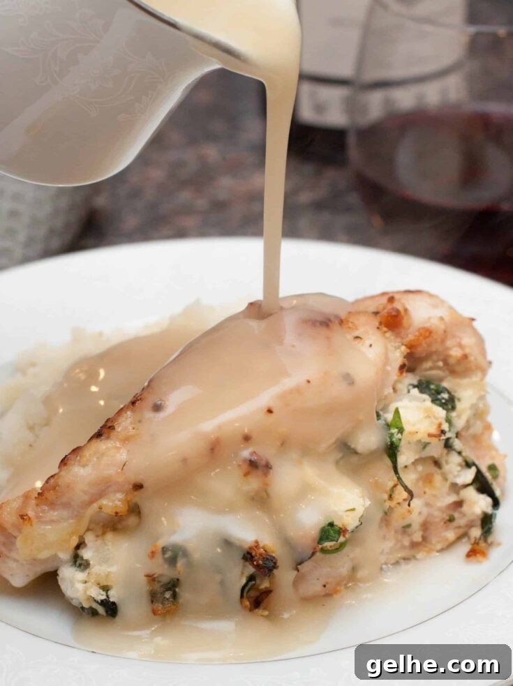 One piece of chicken on plate with mashed potatoes and gravy being poured.