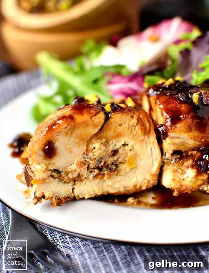 Side closeup of one breast cut in half showing filling, plated with salad.