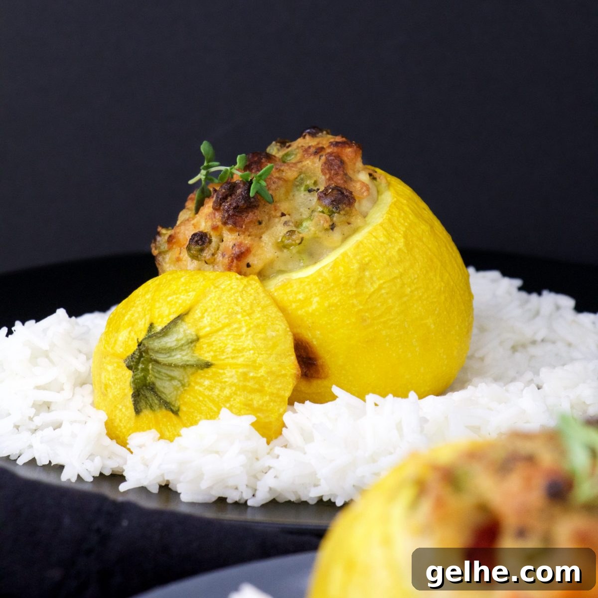 Closeup of stuffed squash amid rice on black plate.