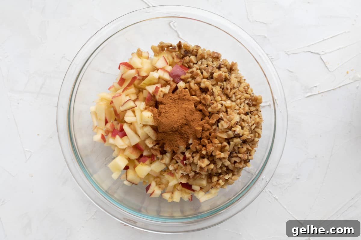 diced apples, chopped nuts and cinnamon in a bowl