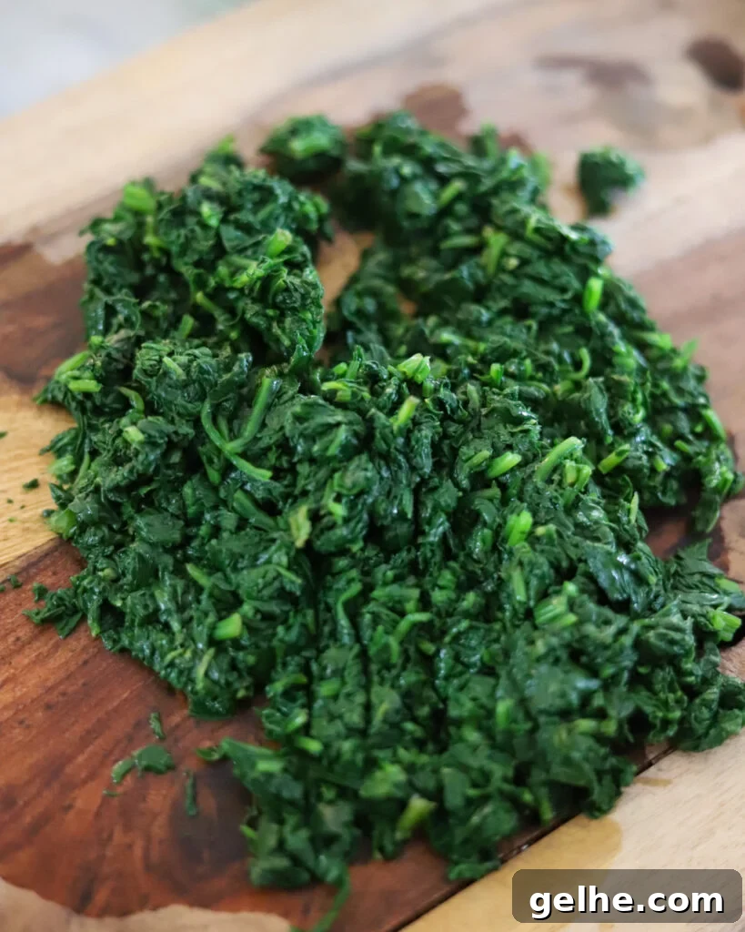 blanched and strained spinach on a cutting board.