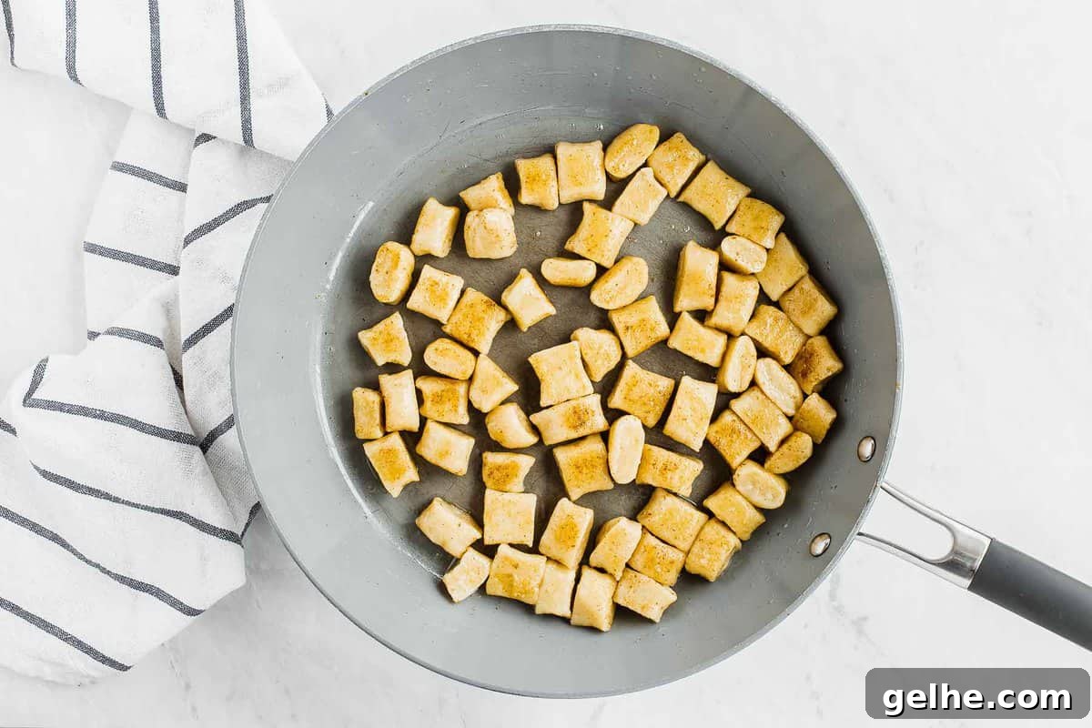 Cooked gnocchi, tossing in butter in skillet.