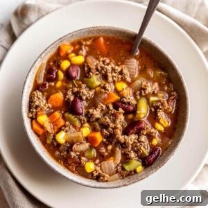 Hearty Ground Beef and Vegetable Soup Recipe 6 A bowl of soup filled with ground beef and veggies.