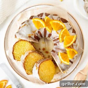Top view of white plate with orange bundt cake with glaze. White background.
