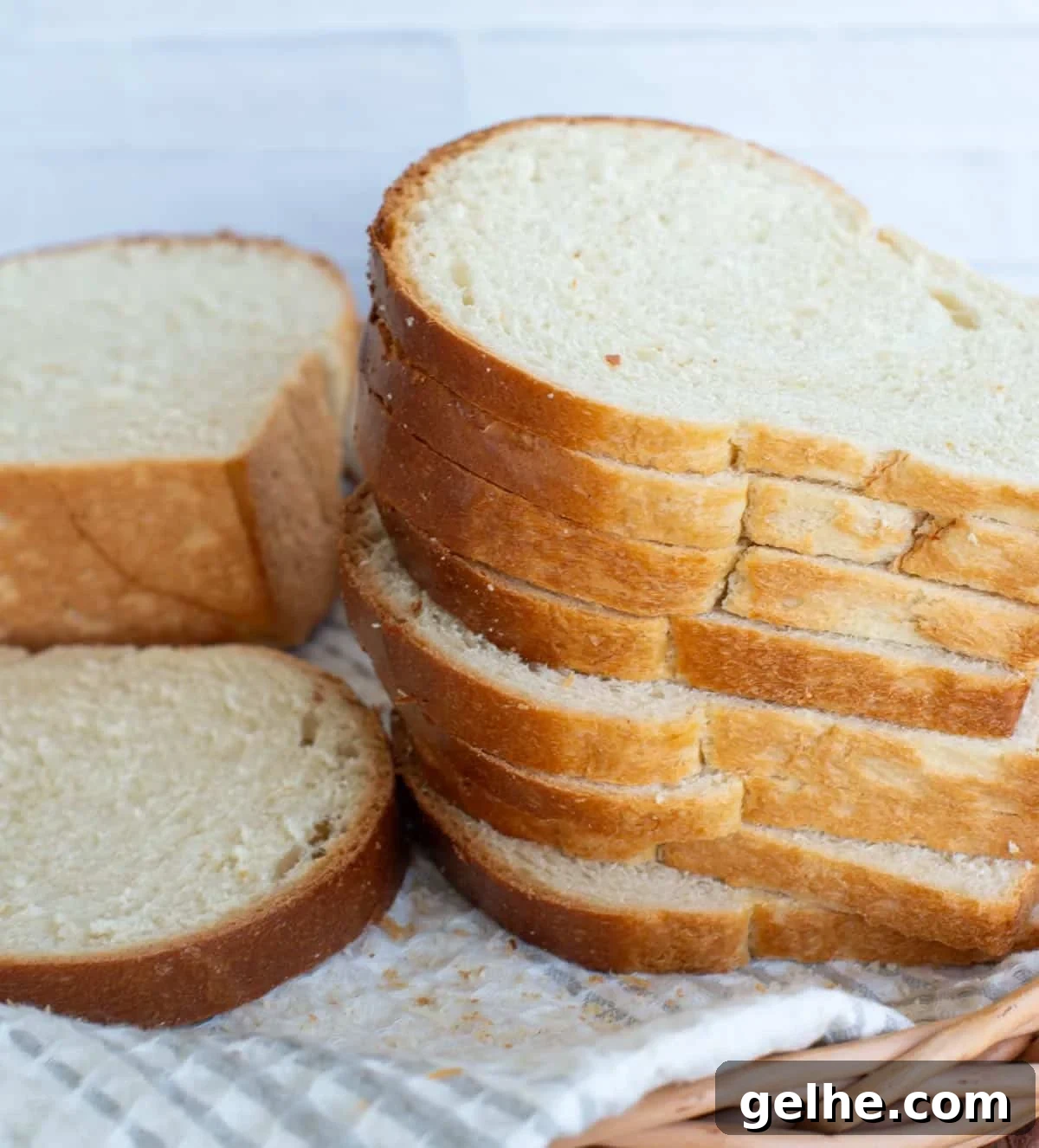 Stacks of sliced white sandwich bread sit in a bread basket.