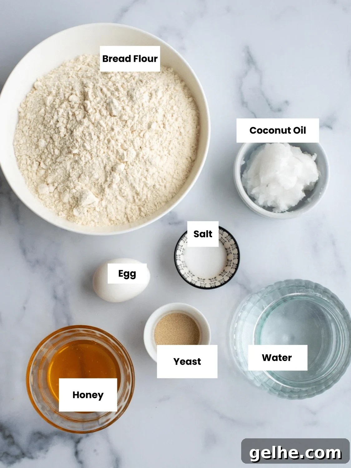 Ingredients on a counter include bread flour, coconut oil, salt, an egg, yeast, honey, and water.