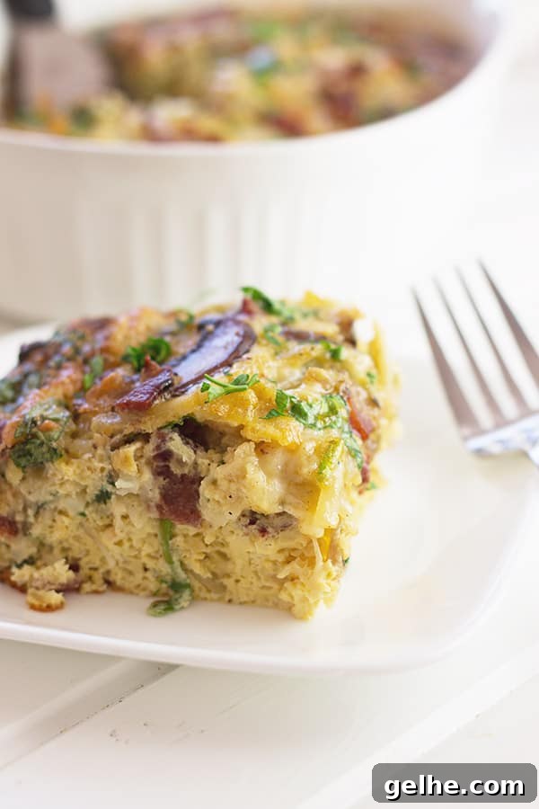 a close up photo of a slice of bacon, mushroom and spinach breakfast casserole