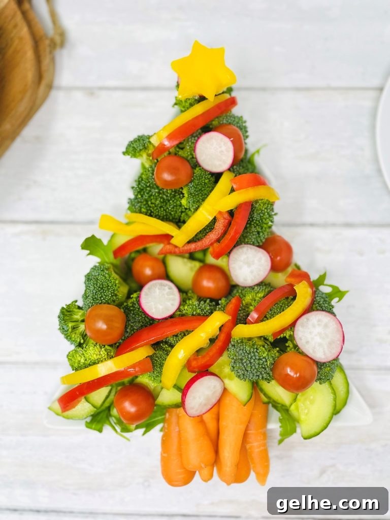 crudite Christmas tree platter - raw veg made into the shape of a christmas tree - includes broccoli, cucumber, carrots, celery, bell peppers, radish and tomatoes