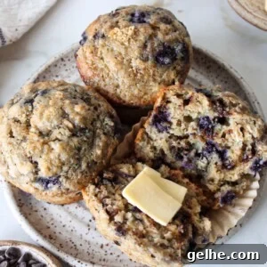 Blueberry chocolate chip muffins on a plate with butter.