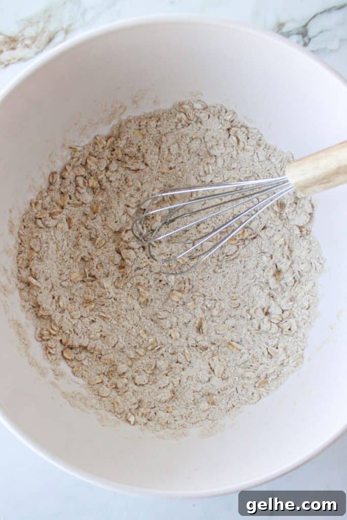 Dry ingredients for blueberry chocolate chip muffins combined in a bowl with a whisk.
