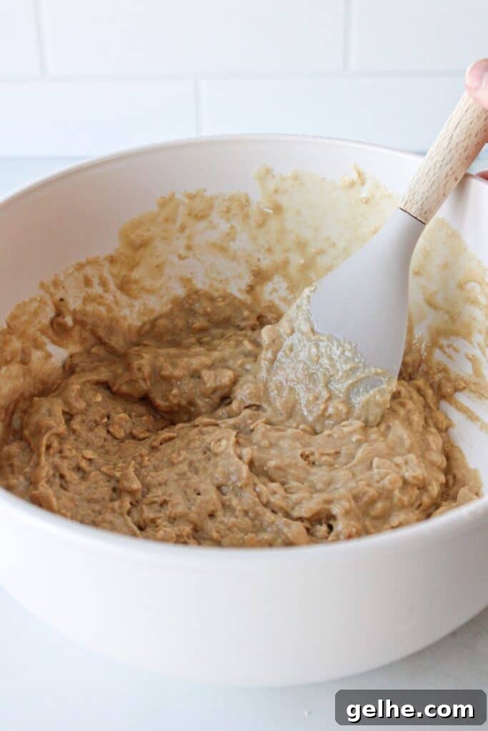 Blueberry chocolate chip muffin batter in a white bowl with a spoon.