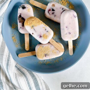 Mini blueberry cheesecake popsicles on a blue plate.