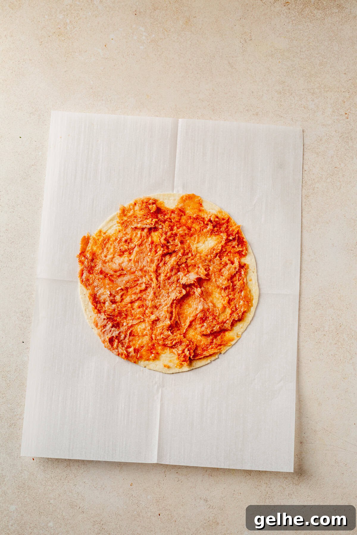 ground chicken mixture spread out onto a large tortilla.