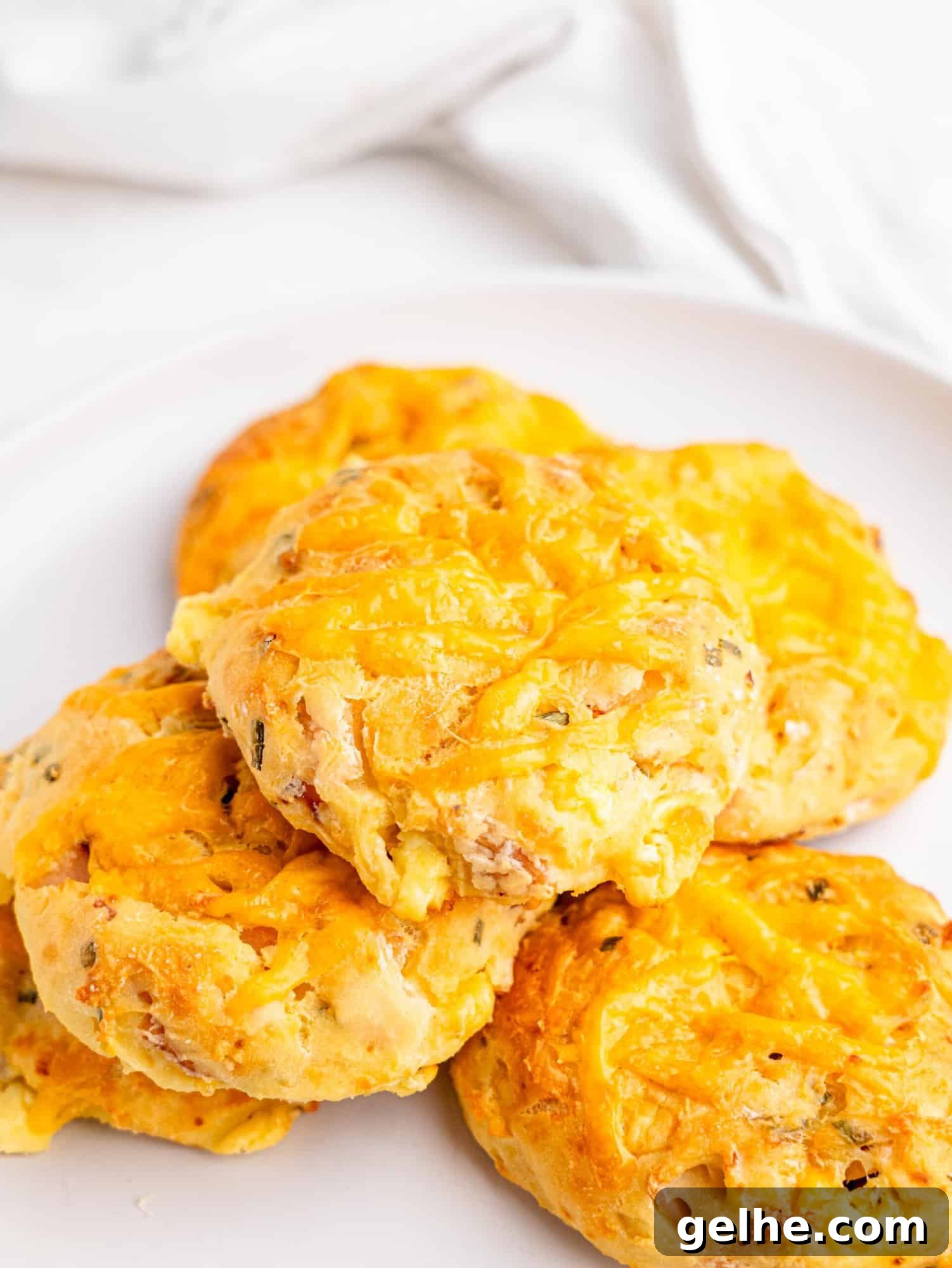 High-Protein Biscuits Without Butter – Fluffy, Low-Fat Recipe 2 Protein biscuits with ham and cheese on a white plate.