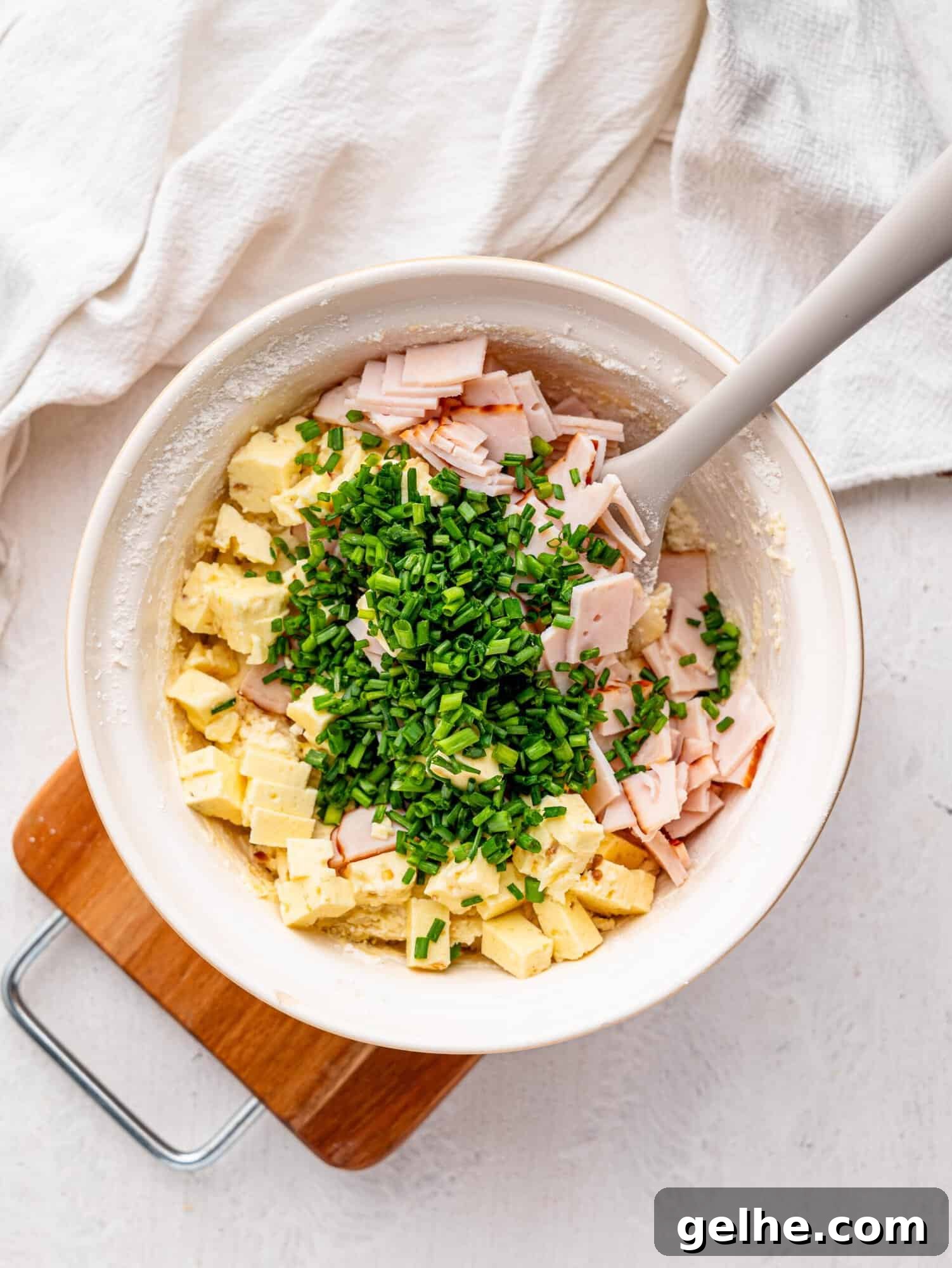 High-Protein Biscuits Without Butter – Fluffy, Low-Fat Recipe 11 High protein biscuit dough with feta, ham and chives in a mixing bowl.