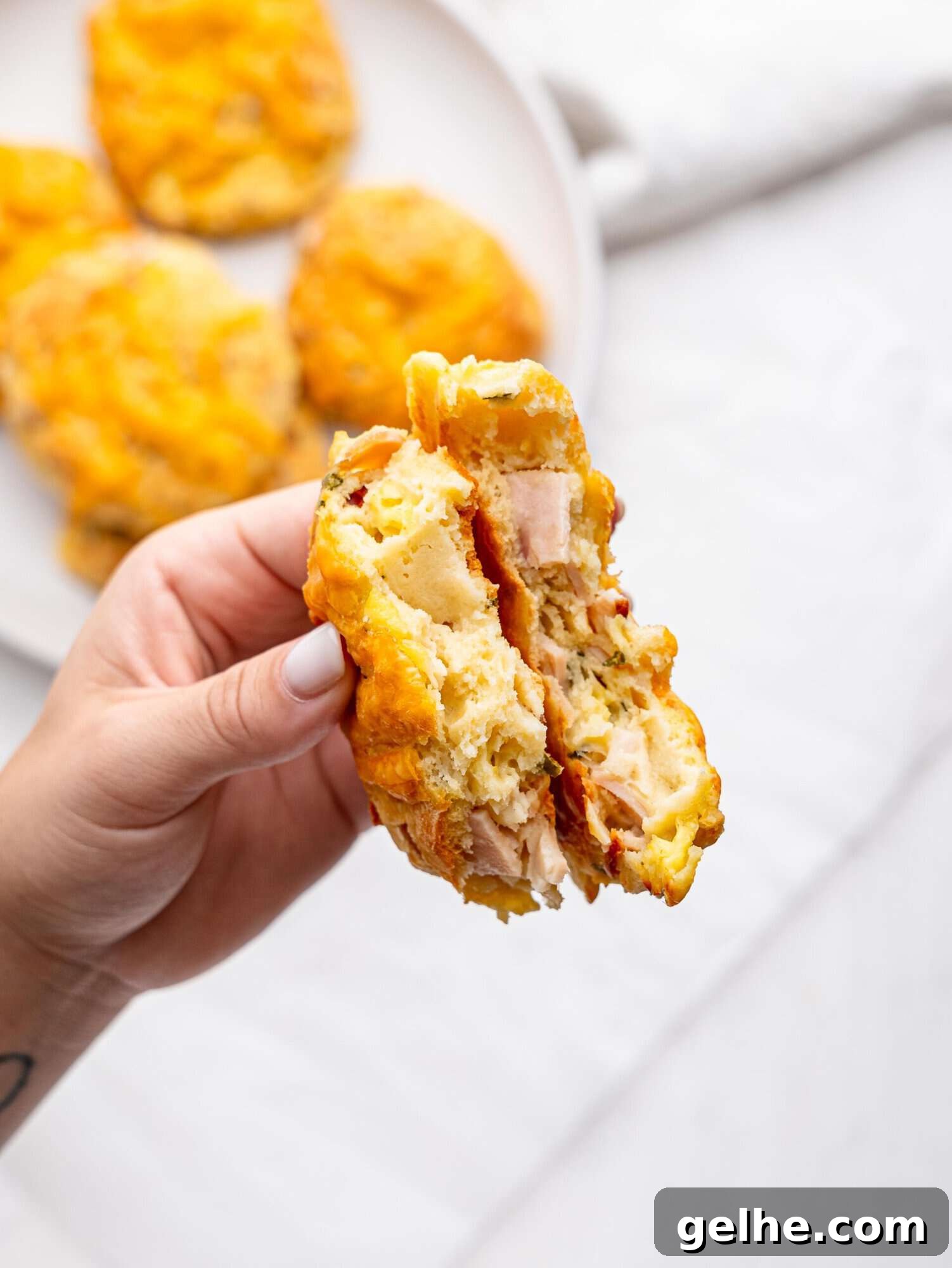 High-Protein Biscuits Without Butter – Fluffy, Low-Fat Recipe 6 A hand holding a protein bagel broken in half.