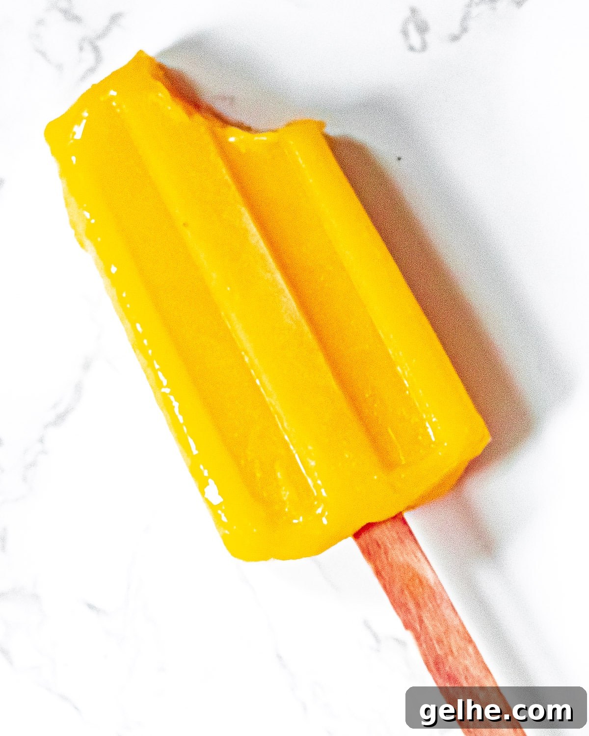 Homemade Mango Popsicles Recipe — Refreshing Summer Treat 3 mango popsicle with a bite taken out