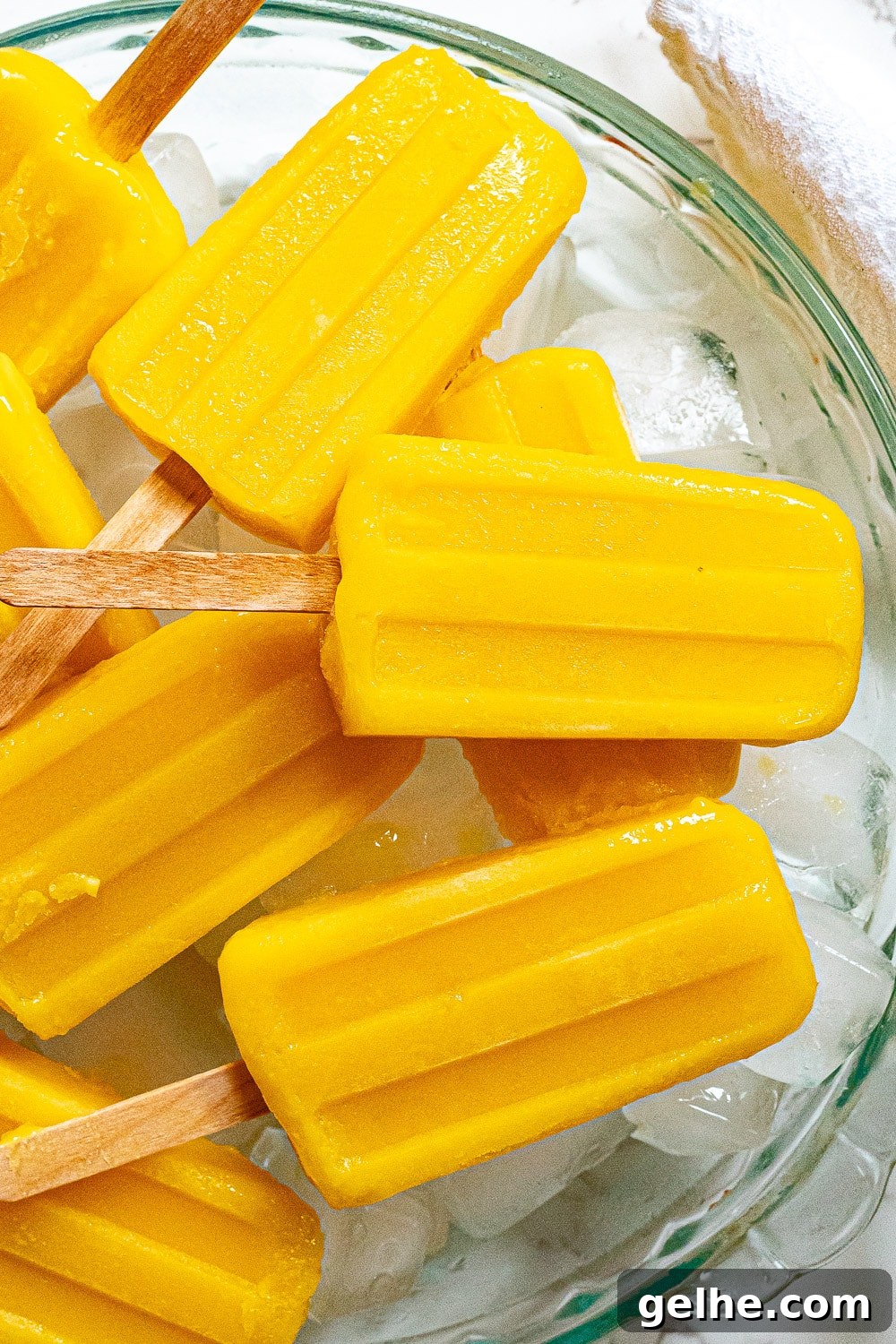 Homemade Mango Popsicles Recipe — Refreshing Summer Treat 6 mango popsicles on a tray with ice
