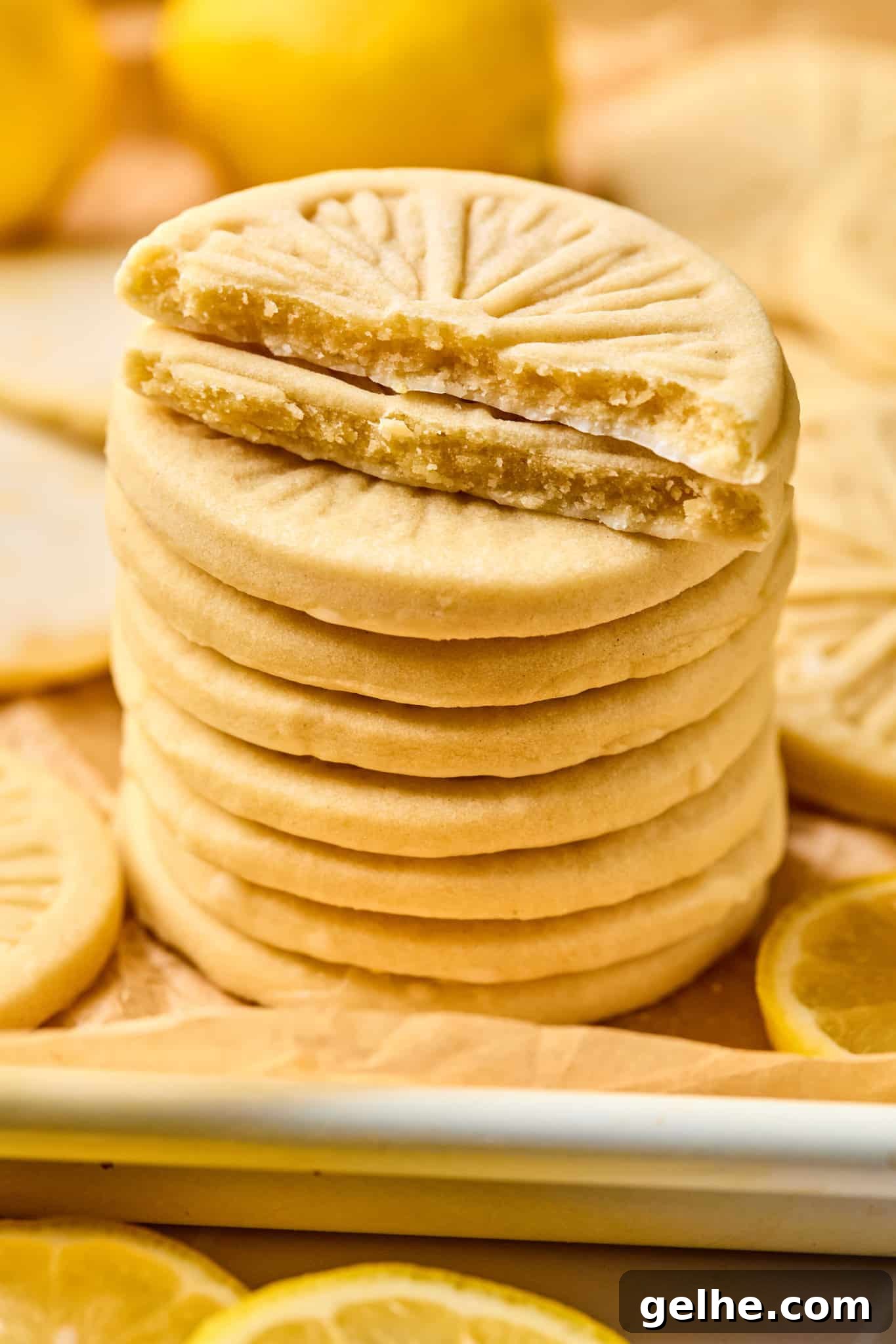 Homemade Girl Scout Lemonade Recipe: Refreshing Copycat Version 4 Stack of copycat girl scout lemonade cookies on parchment-lined baking sheet. The top two cookies are cut in half so you can see the middle of the cookie.