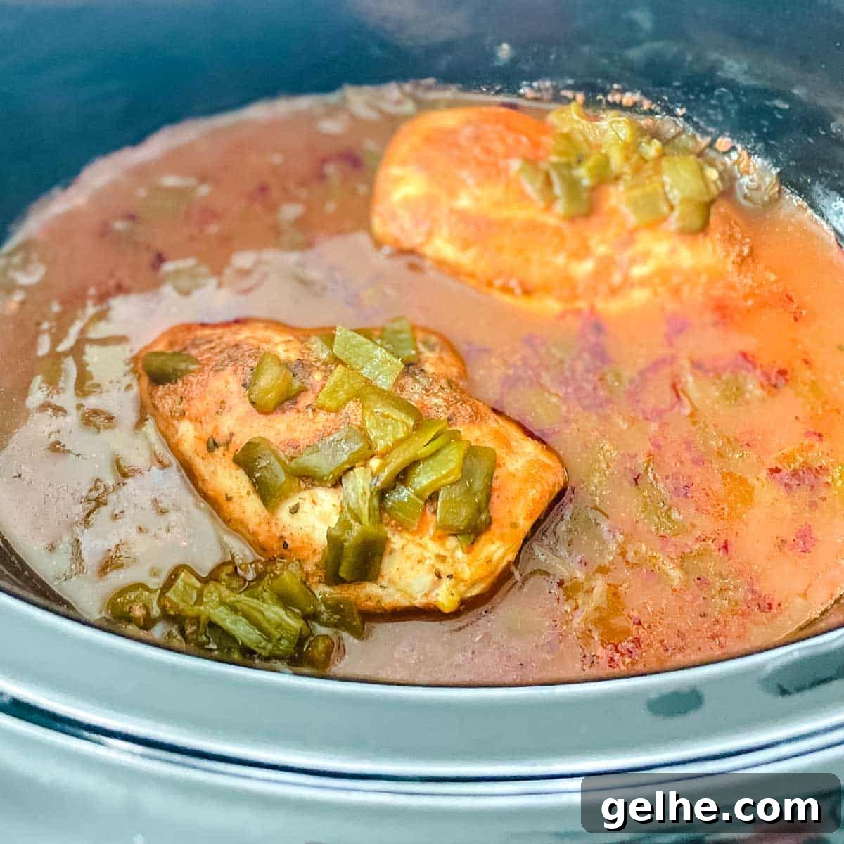 Slow Cooker Shredded Chicken Enchiladas Recipe 7 Cooked chicken in enchilada sauce is shown in the slow cooker.