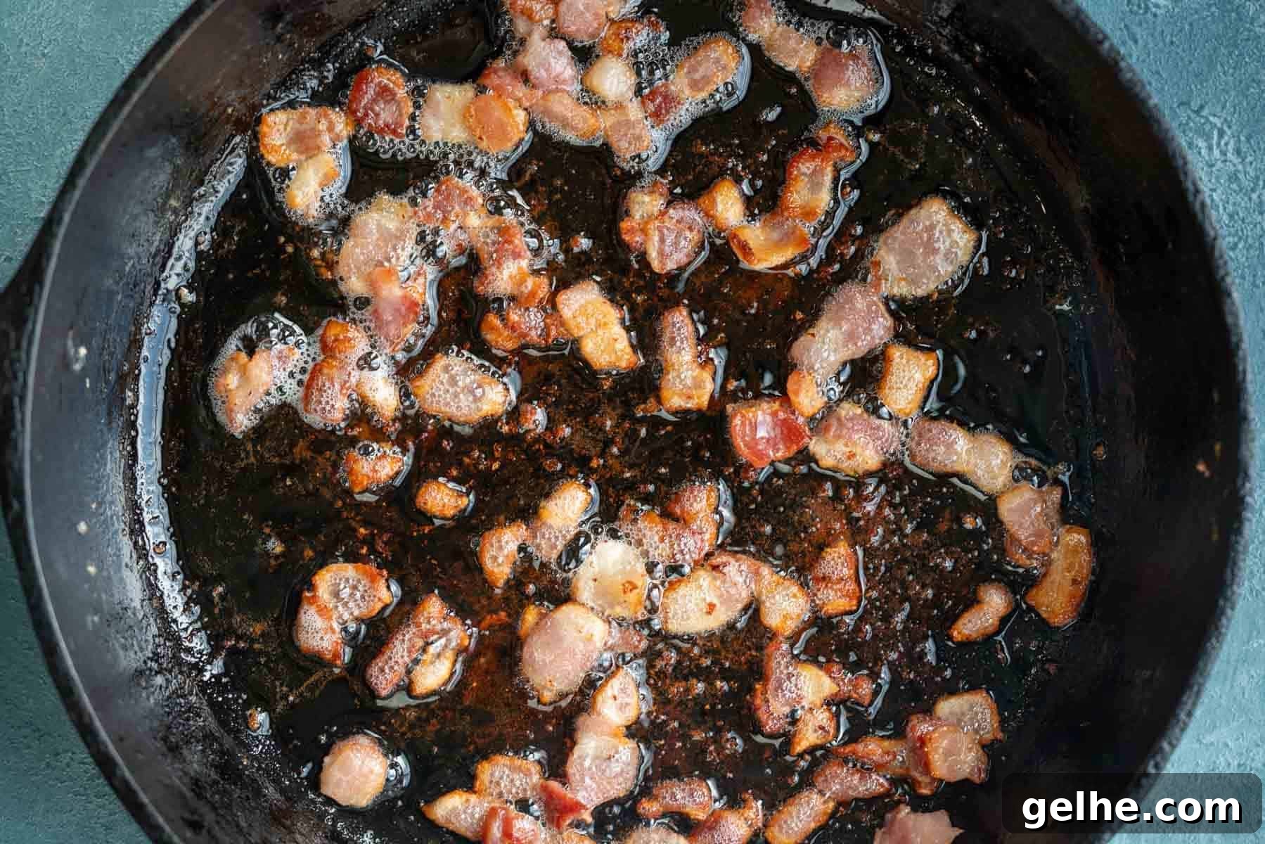 chopped bacon crisping up in a cast iron skillet