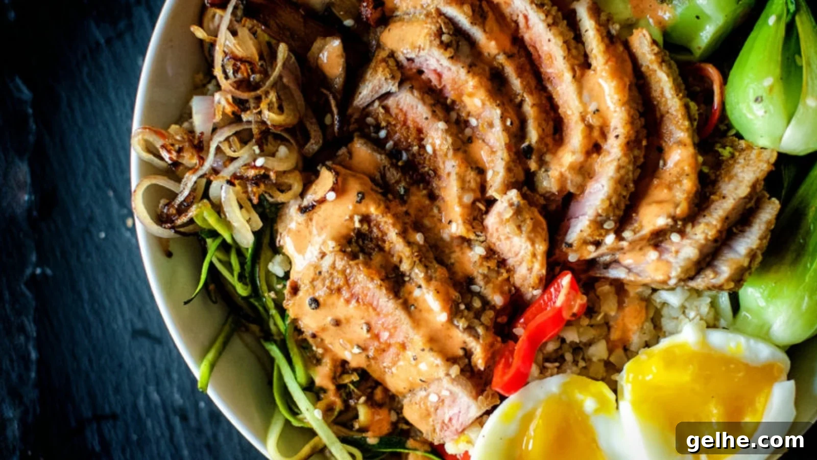 Tuna bowl with sesame crusted tuna slices over rice and vegetables.