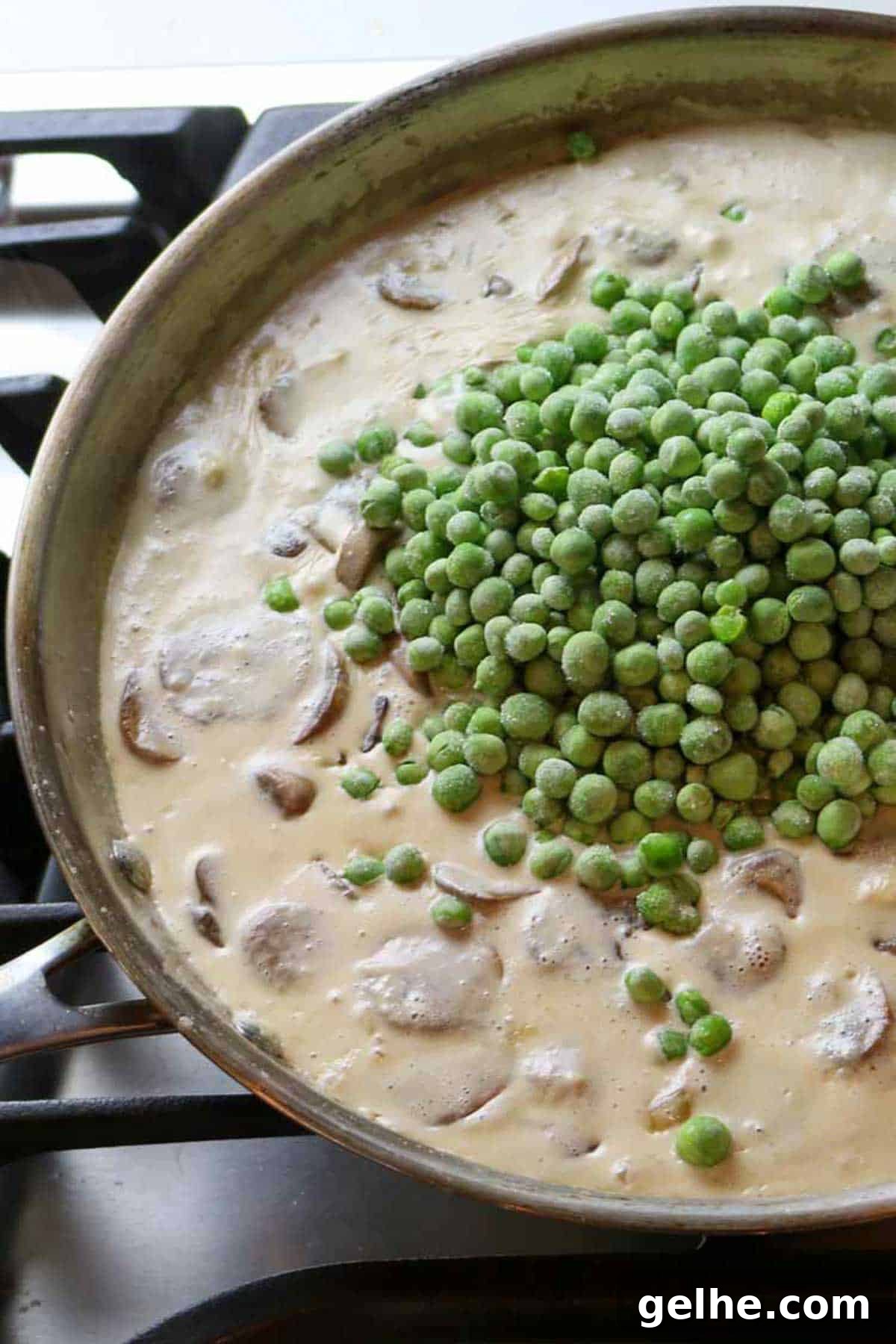 creamy mixture with mushrooms and peas added on top.