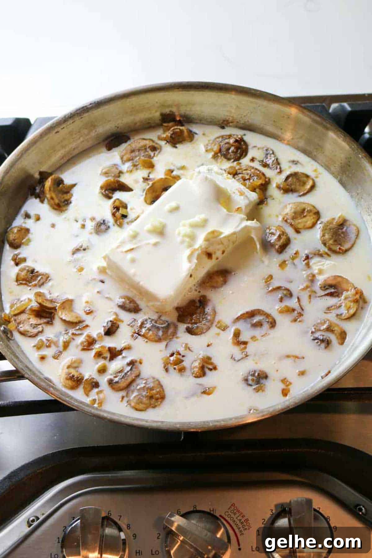 cream cheese block added to milky mushroom mixture in large skillet.