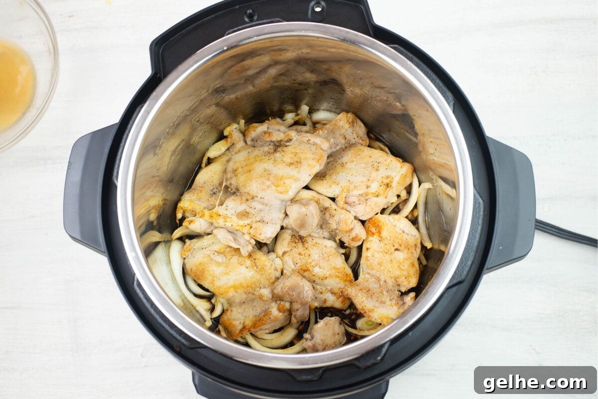 Adding the browned chicken to the seasonings and sauce ingredients.