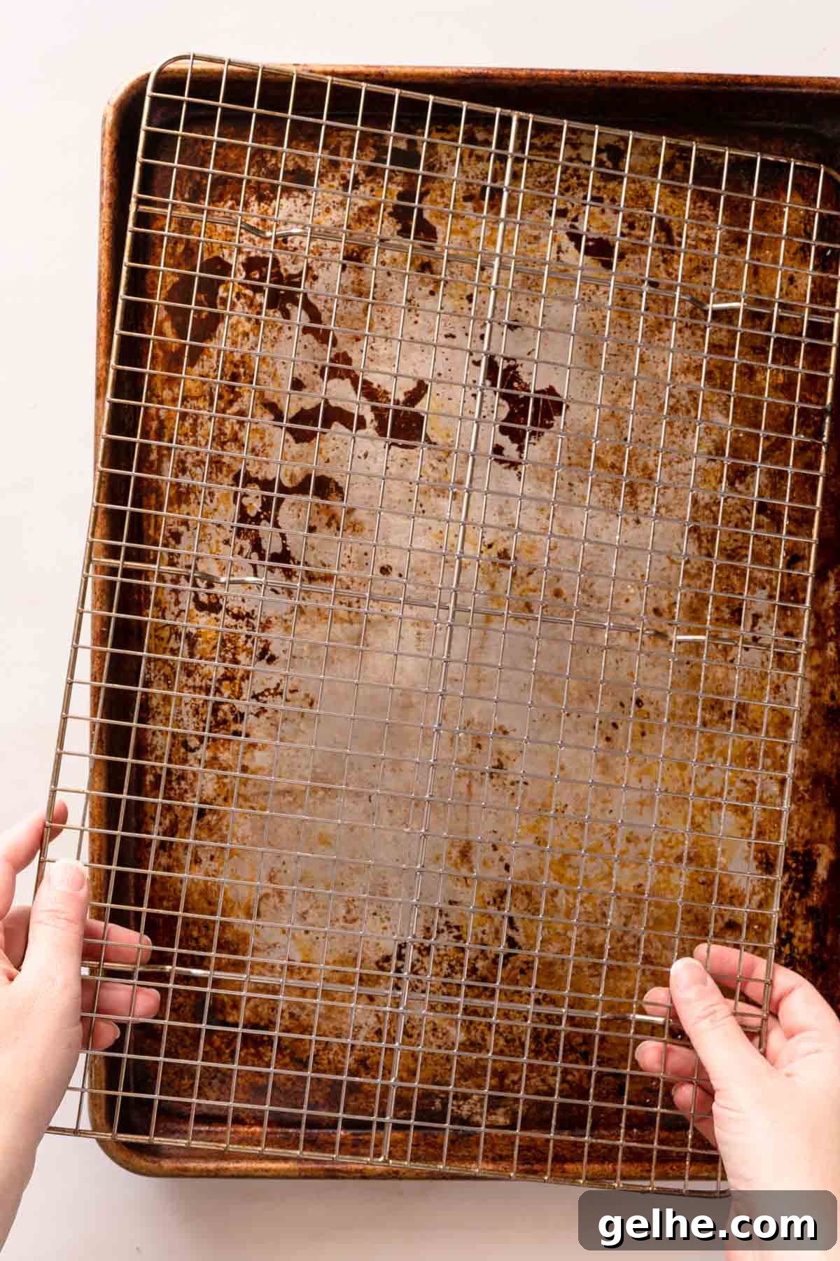 Crispy Panko-Baked Chicken Breast Recipe 4 hands placing wire rack on top of metal baking pan