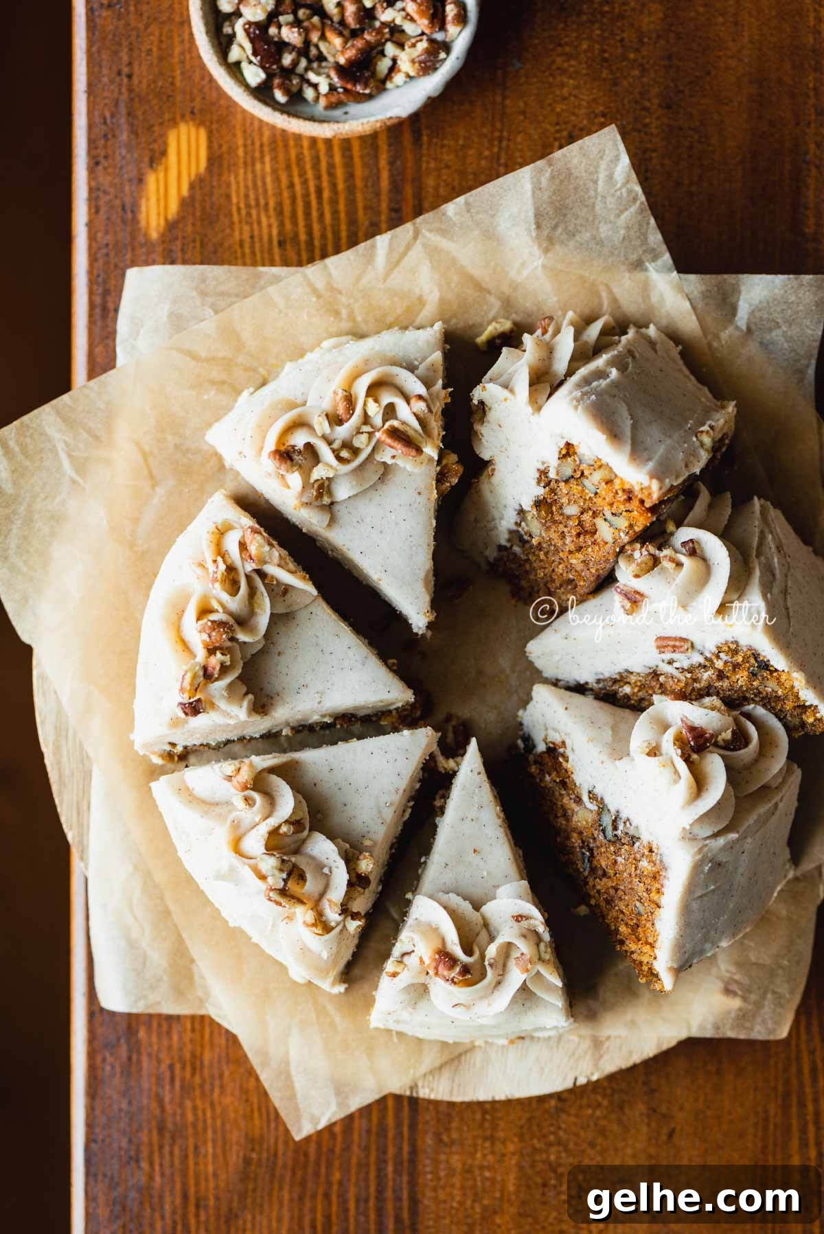 Moist One-Layer Carrot Cake Recipe for Any Occasion 2 Overhead image of single layer carrot cake frosted on parchment paper and placed on a wood dining room table | All Images © Beyond the Butter®