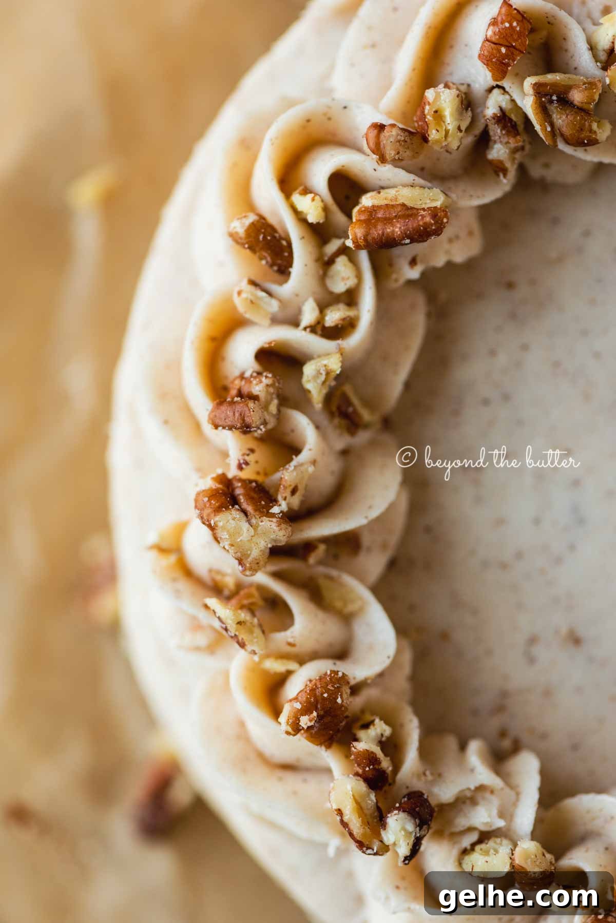 Moist One-Layer Carrot Cake Recipe for Any Occasion 9 Detailed closeup image of frosted 6 inch carrot cake on sheets of brown parchment paper | All Images © Beyond the Butter®