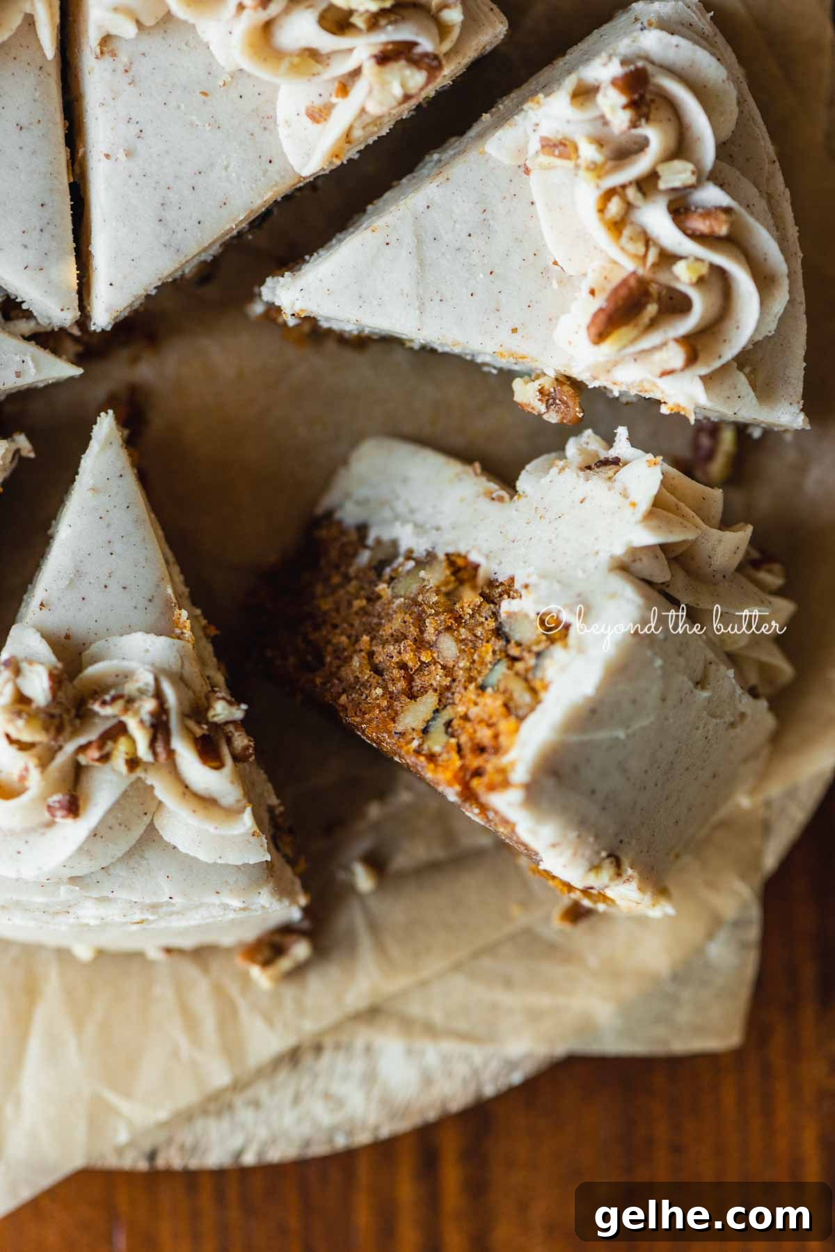 Moist One-Layer Carrot Cake Recipe for Any Occasion 3 Overhead closeup image of single layer carrot cake frosted on parchment paper and placed on a wood dining room table | All Images © Beyond the Butter®