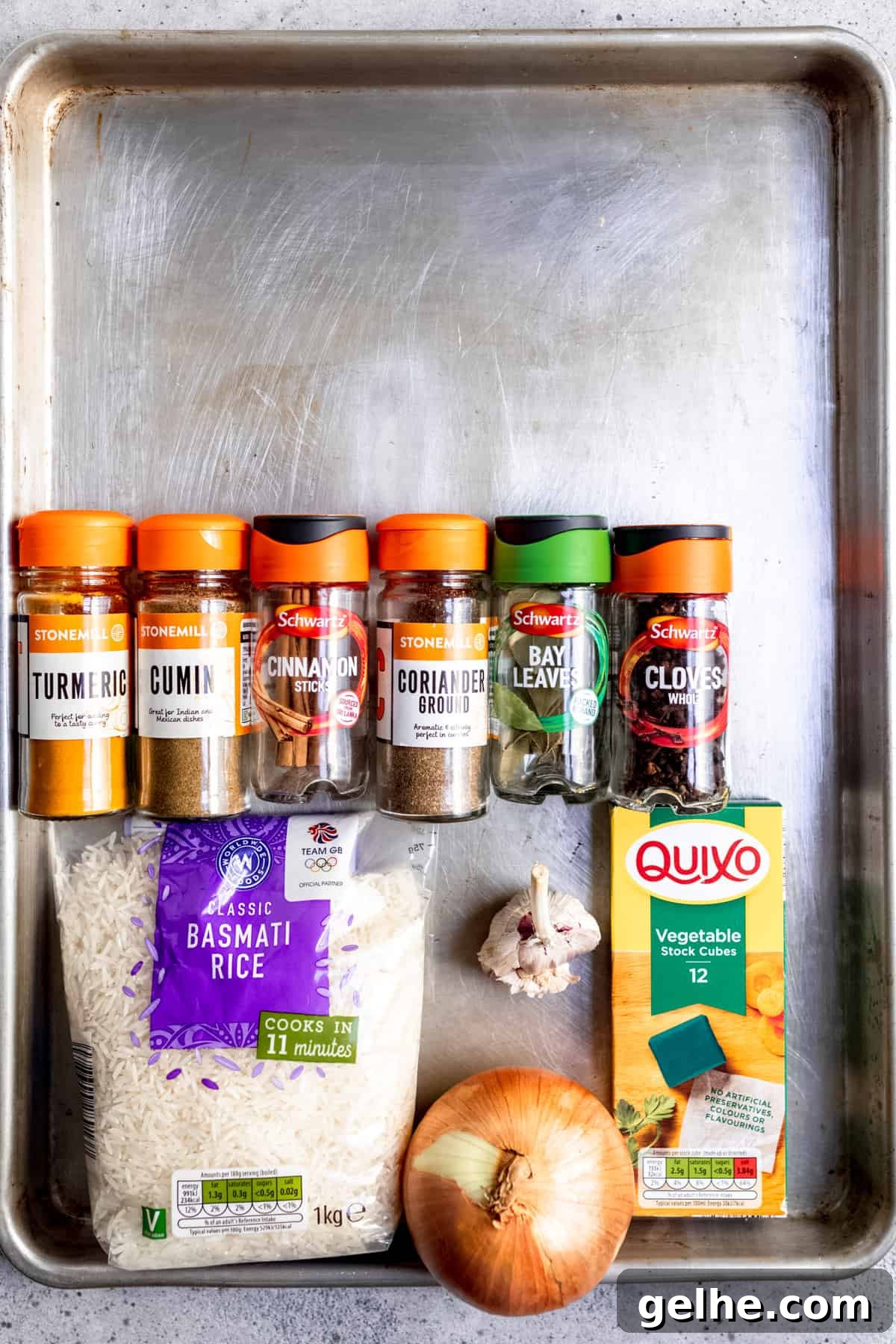 Ingredients for pilau rice and seasoning on a baking tray.