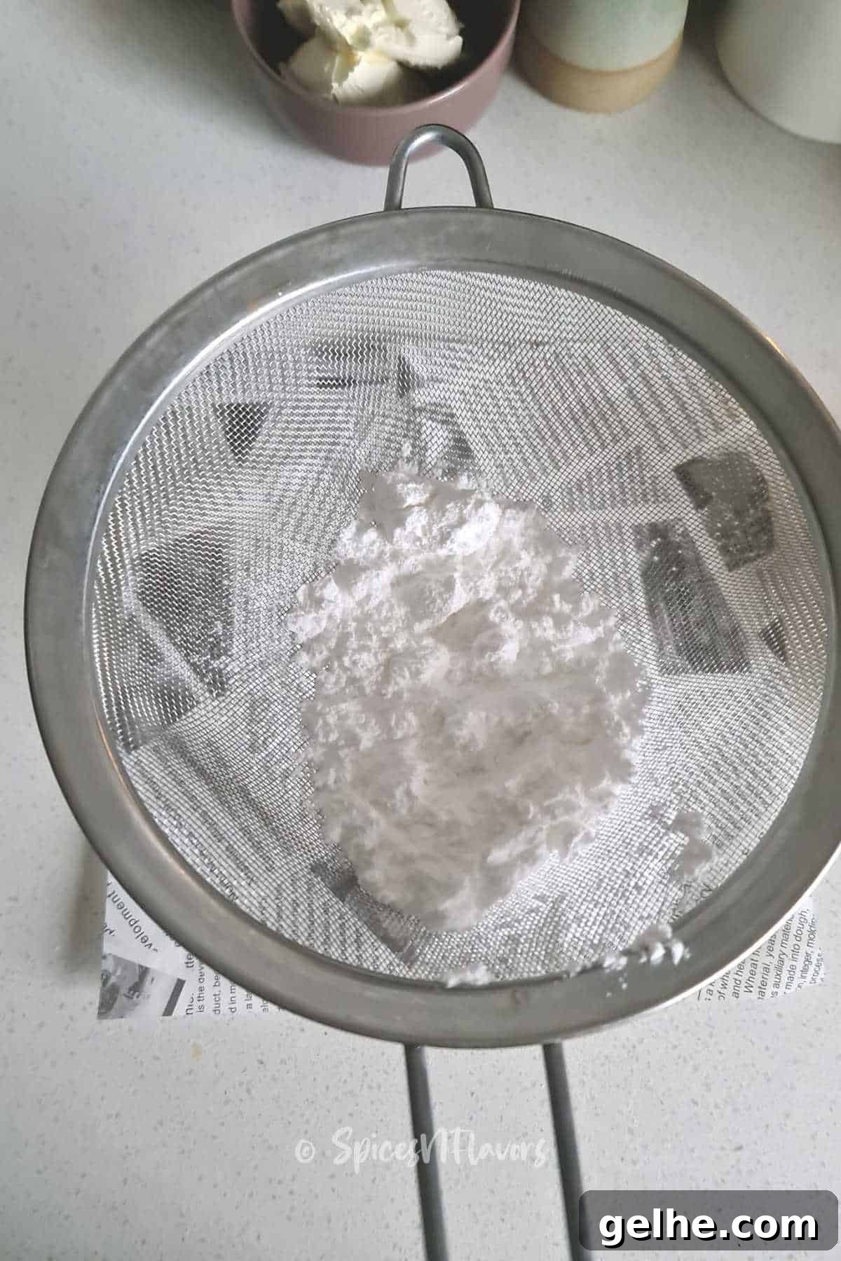 sieve the icing sugar using a sieve on a white paper