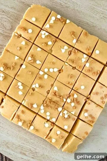 Pumpkin spice fudge cut into squares on a wooden cutting board.