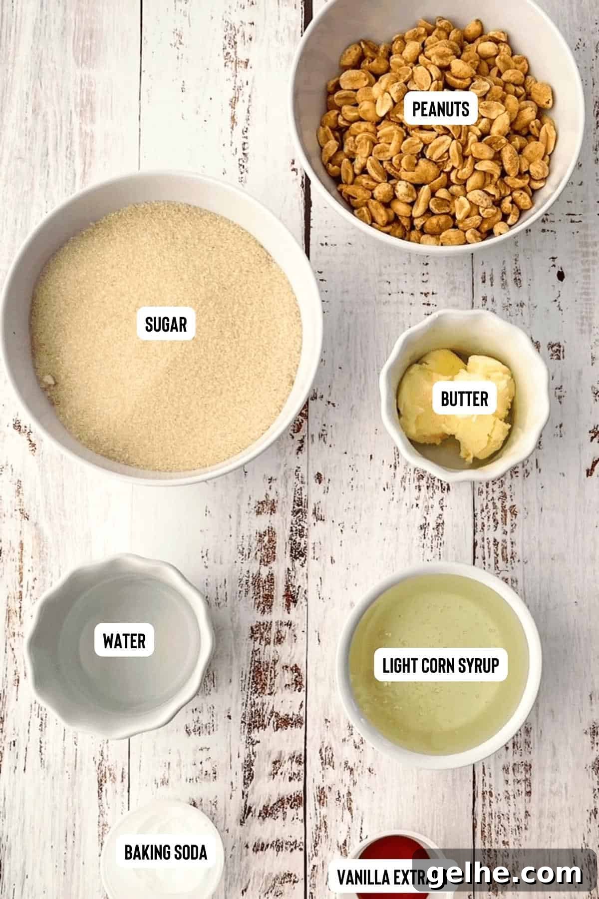 Ingredients for soft peanut brittle measured out and placed in white bowls, placed on a white table.