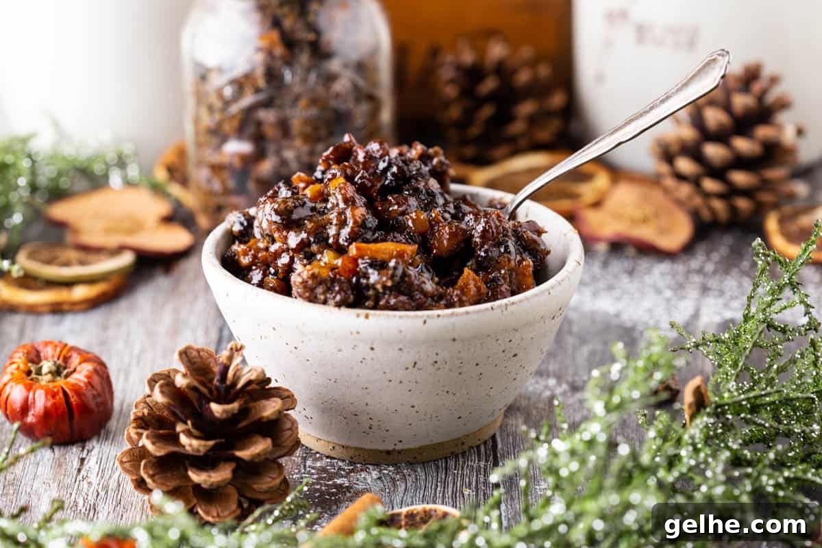Gluten-Free Suet Mincemeat Recipe for Classic Pies 12 Mincemeat ingredients in a bowl on a wooden table with a wooden spoon next to it.