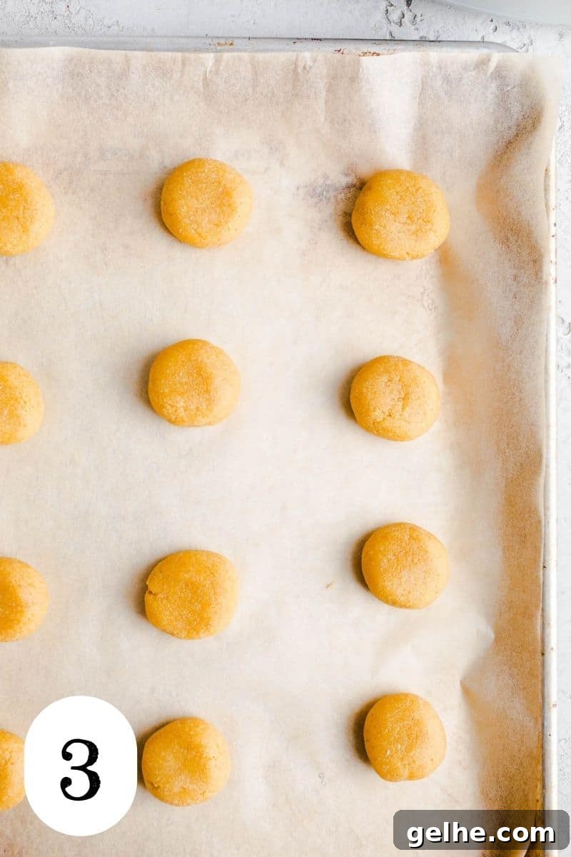 Cookie dough balls on a baking sheet.