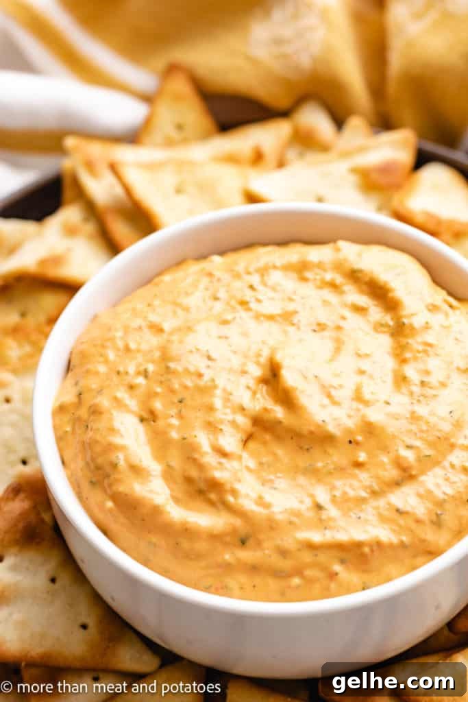 Roasted pepper dip in a bowl with pita chips.