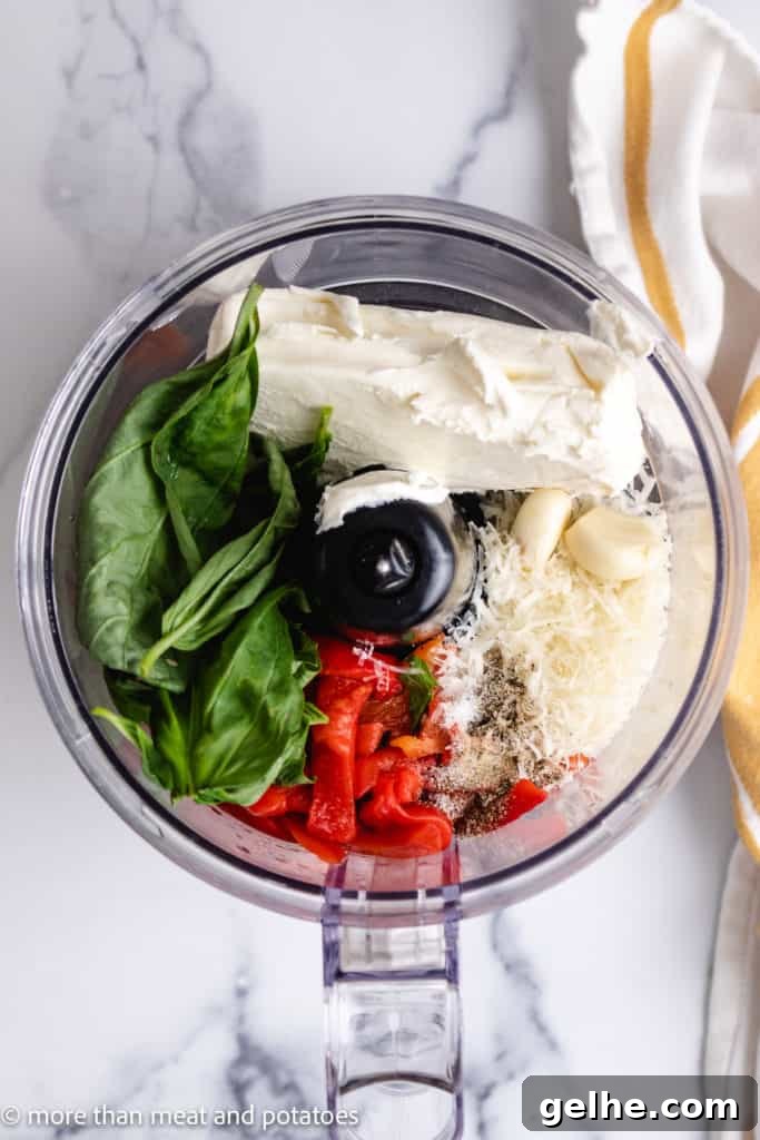Top down view of the ingredients for roasted pepper dip in a food processor.