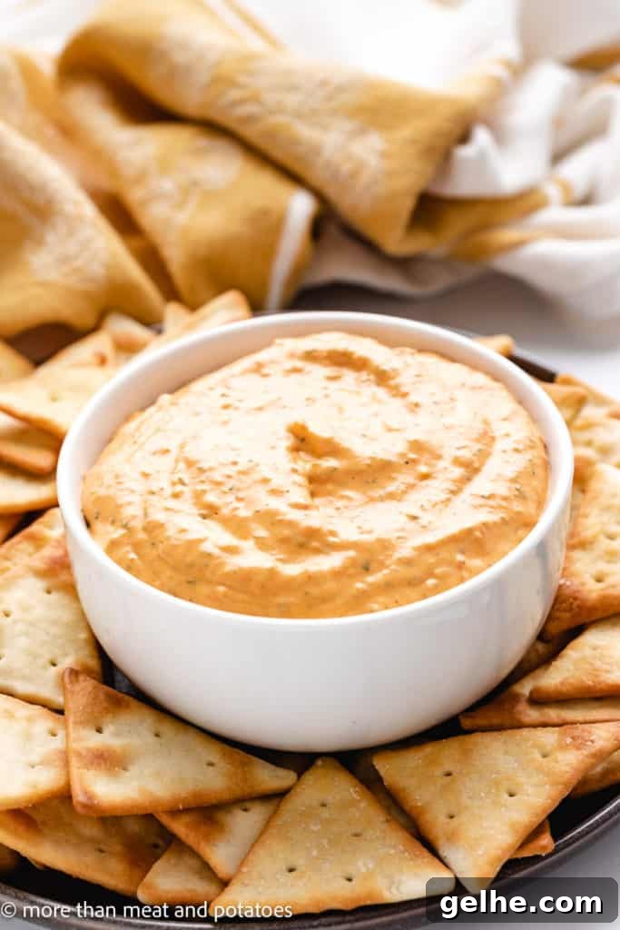 Roasted pepper dip in a dish with crackers.