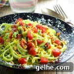 A plate of zoddles topped with roasted tomatoes and parmesan cheese